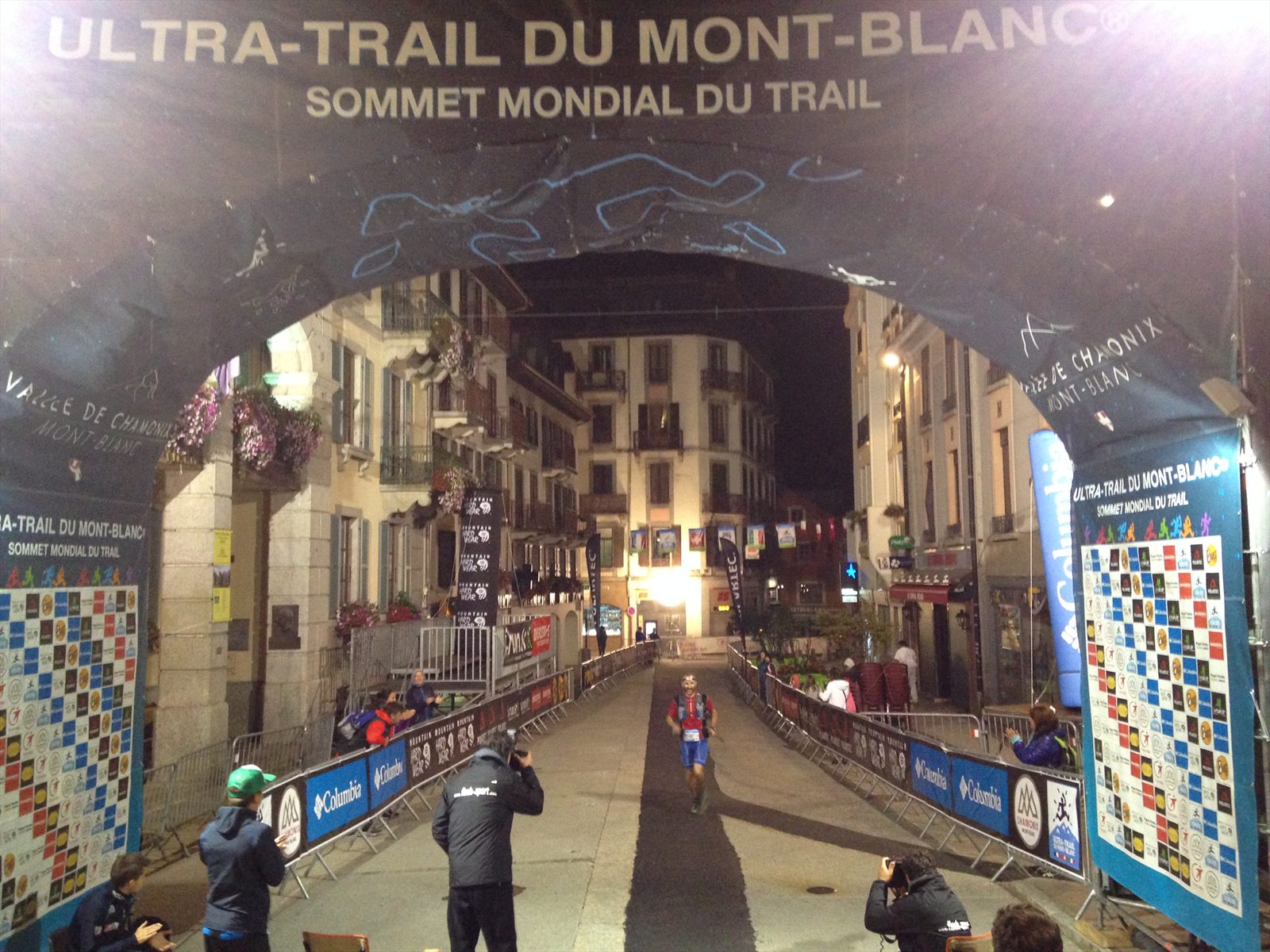 Jonas på upploppet under den upplysta UTMB-målportalen i Chamonix mitt i natten